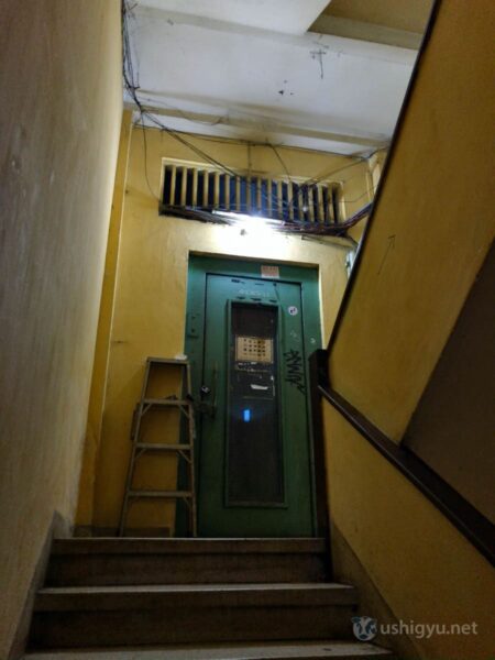 怪しげなマンションの階段を上る